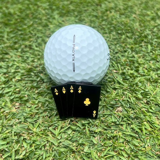 Detailed shot of the dirty birdie ball marker leaning against golf ball on putting green