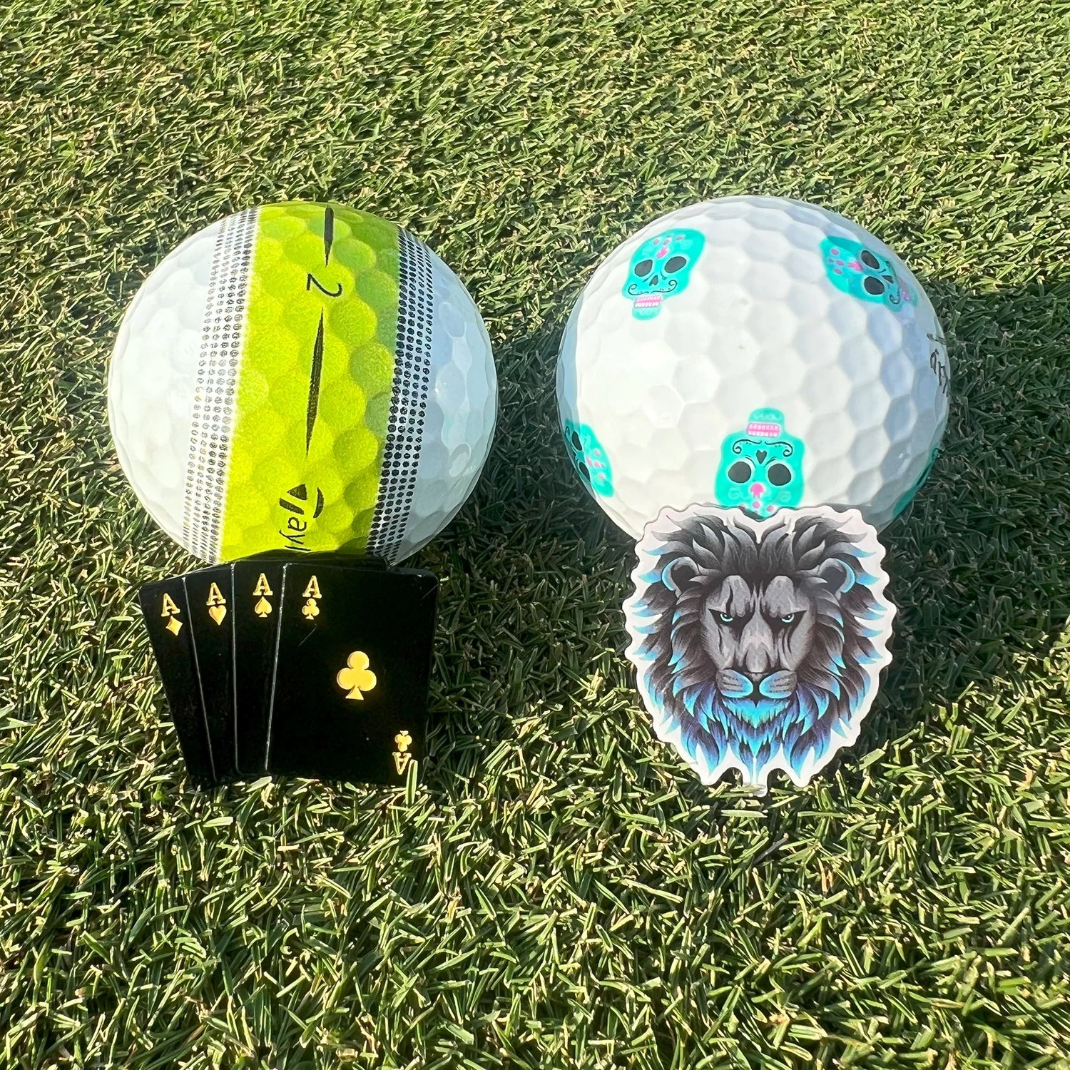 Premium golf ball markers resting against ball on green during putting setup