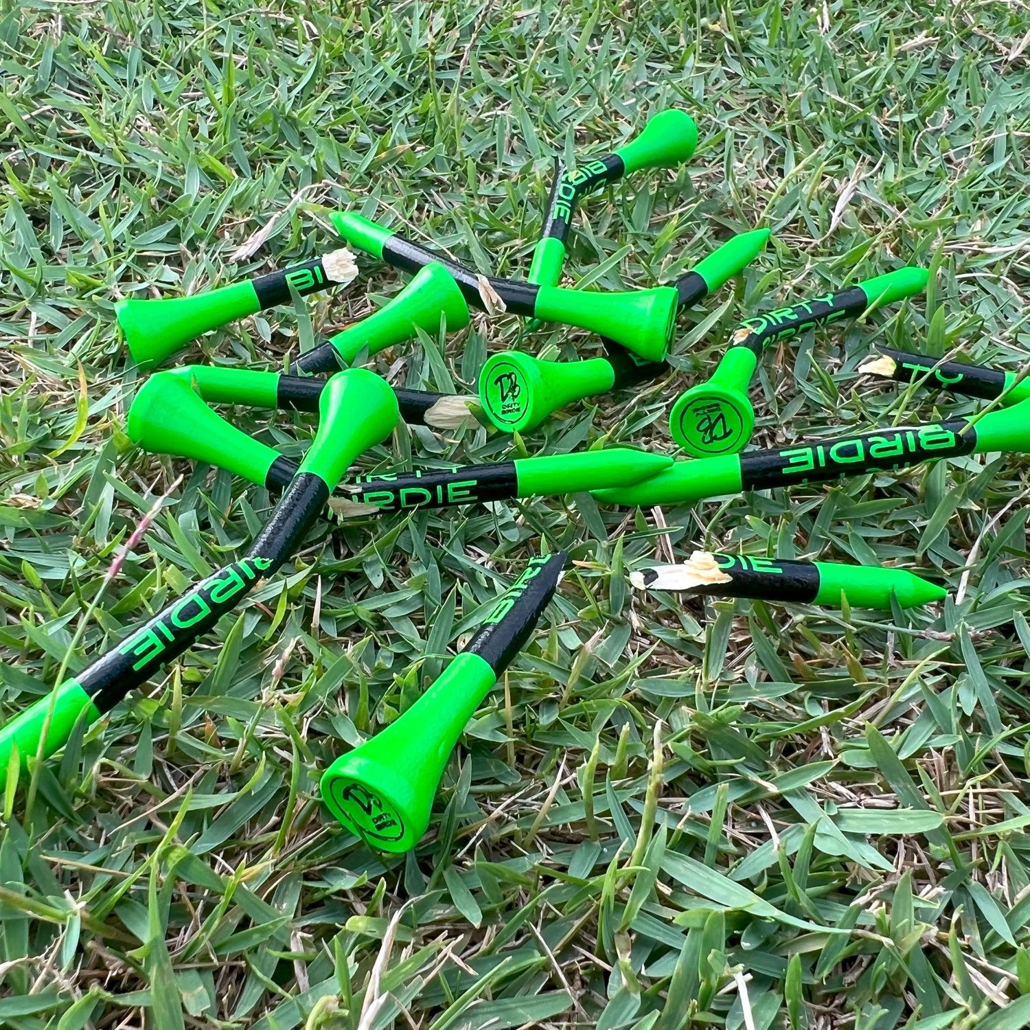 Snapped bamboo golf tees on grass, highlighting their biodegradable nature over plastic
