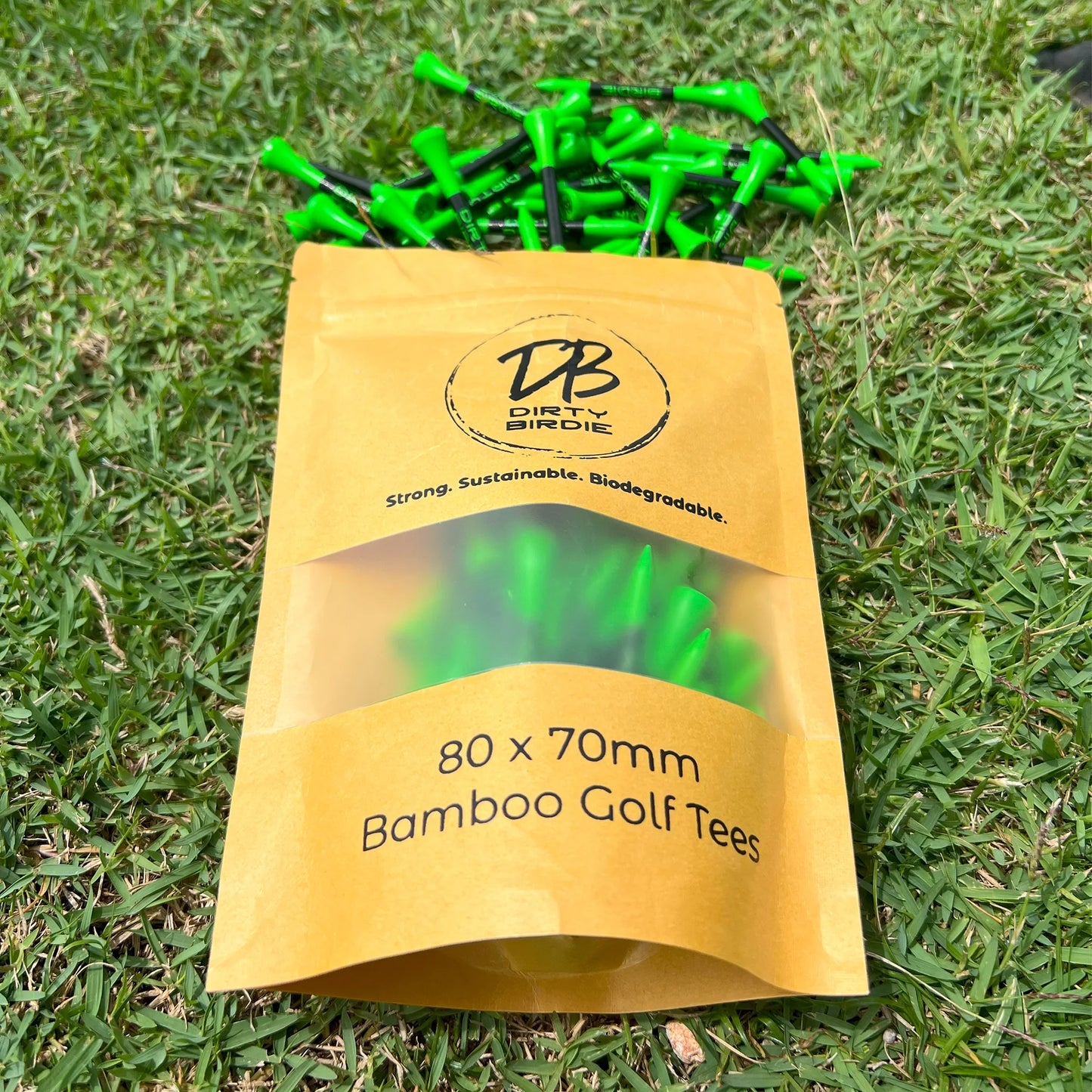 Resealable bag of strong golf tees spilling out onto tee box grass in sun