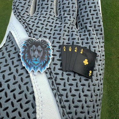 Detailed golf ball markers held in gloved hand showing size and finish 