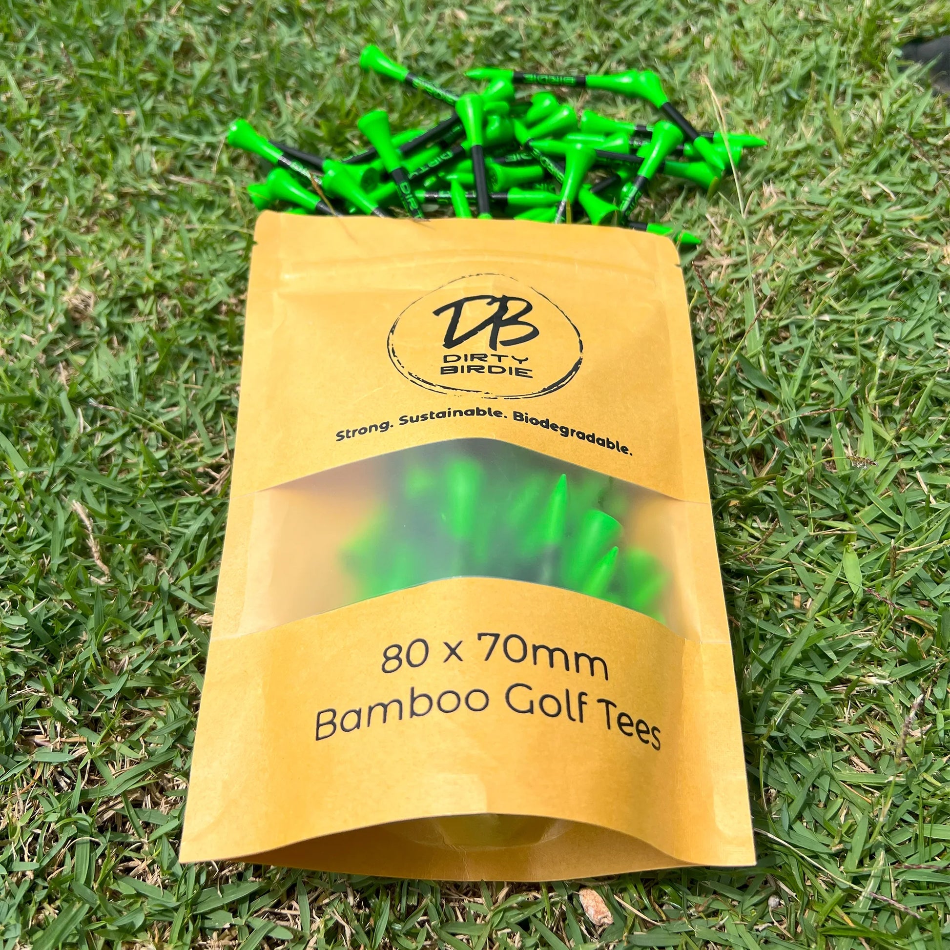 Resealable bag of strong golf tees spilling out onto tee box grass in sun